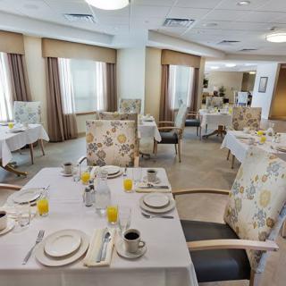 A well-lit dining room with elegantly set tables and comfortable chairs.