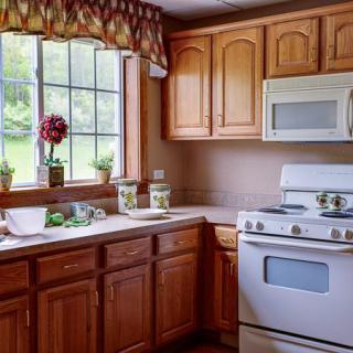 A cozy kitchen with wooden cabinets, a window, and modern appliances.