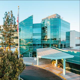 A modern healthcare facility featuring a striking glass exterior and a welcoming entrance.
