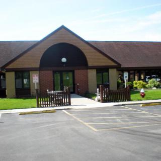 Exterior view of a building with an entrance and surrounding landscape.