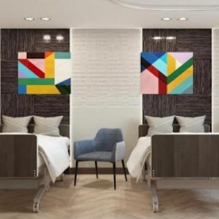 A modern hotel room featuring twin beds and vibrant abstract art on the walls.