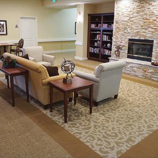 A cozy living room with sofas, a fireplace, and a bookshelf.