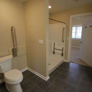 A handicap-accessible bathroom with grab bars and a walk-in shower.