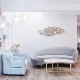 A modern living room with a curved sofa, matching armchair, and minimalist decor.