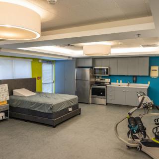 A modern interior featuring a bedroom with a kitchenette and contemporary furniture.