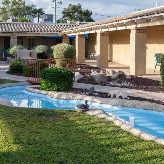 A tranquil courtyard features a landscaped garden with a small water feature and well-maintained pathways.