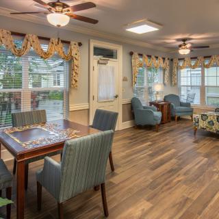 A cozy living room with wooden flooring, ceiling fans, and comfortable seating.