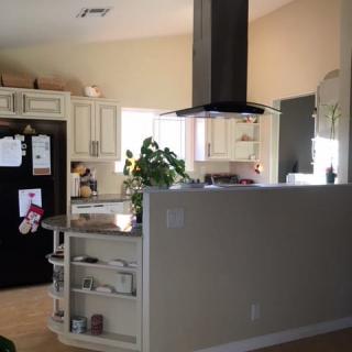A cozy kitchen with a central island, surrounded by cabinets and appliances.