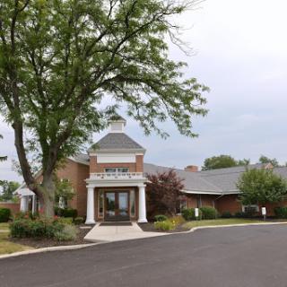 A welcoming entrance to a facility surrounded by greenery.