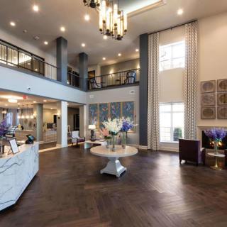 A modern hotel lobby with elegant decor and a large chandelier.