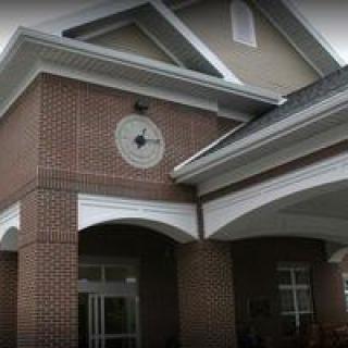 A brick building entrance with a clock above the doorway.