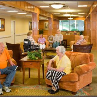 Seniors socializing in a comfortable lounge area of a retirement home.