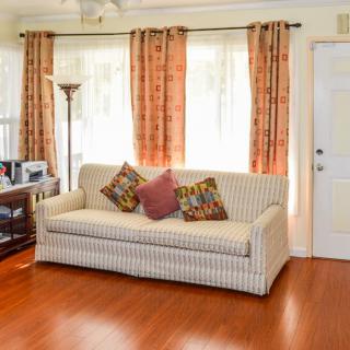 A cozy living room with a striped sofa, decorative pillows, and warm-toned curtains.