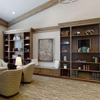 A modern library with comfortable seating and wooden bookshelves.