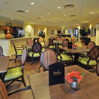 A cozy restaurant dining area with tables and chairs, featuring menus on the tables and warm decor.