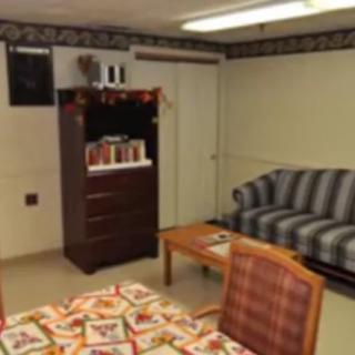 A small office space with a table, chairs, sofa, and cabinet.
