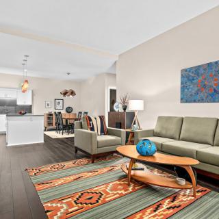 A modern open-plan living room with a stylish kitchen, dining area, and contemporary decor.