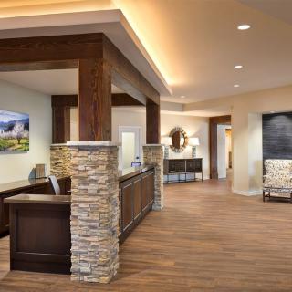 A modern reception area with stone accents and wooden flooring.