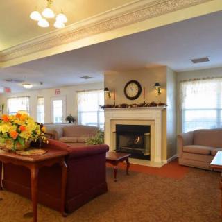A cozy living room with sofas, a fireplace, and floral decor.