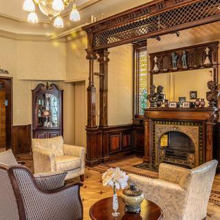 A cozy vintage living room with classic wooden decor and a fireplace.