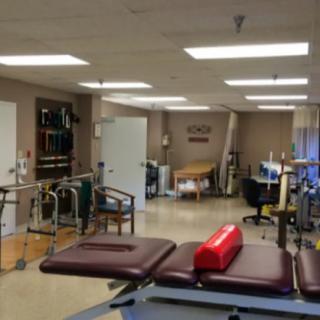 A rehabilitation center equipped with treatment tables and exercise equipment.