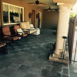 A cozy patio with comfortable seating and decorative columns.
