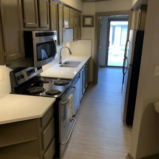 A modern galley kitchen with stainless steel appliances and ample cabinetry.