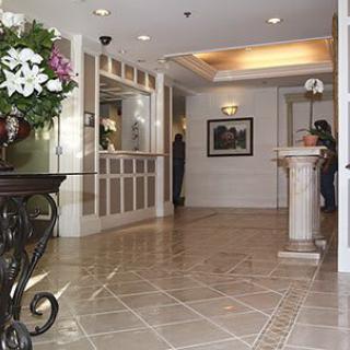 Elegant hotel lobby with a reception desk and floral arrangement.