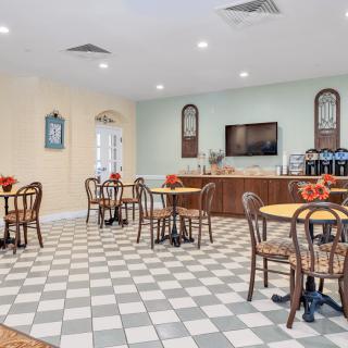 A cozy indoor cafe with checkered flooring and neatly arranged tables and chairs.