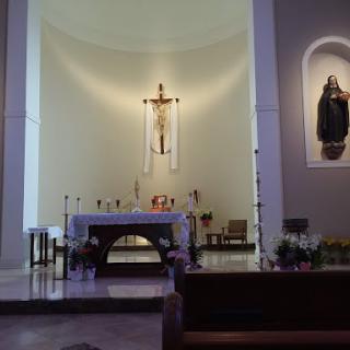 A serene view of the altar in a church, featuring a crucifix and decorative elements.