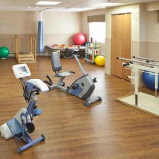 A rehabilitation therapy room equipped with exercise bikes and fitness equipment.