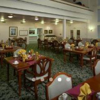 A well-arranged dining area with multiple tables and chairs, elegantly set for guests.