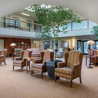 A spacious lounge area with comfortable seating and indoor plants.