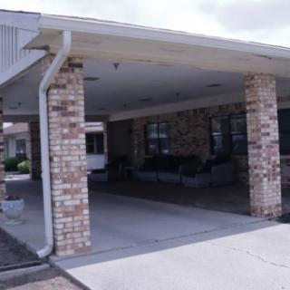 A covered entrance with brick columns providing shelter at the front of a building.