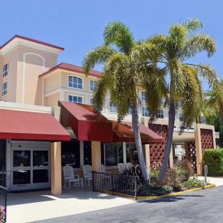 A sunny day at a restaurant with outdoor seating and palm trees.