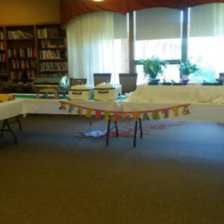 A decorated room with tables set up, likely for an event in a library.
