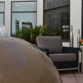 A modern outdoor patio with a comfortable chair and plants.