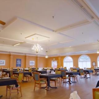 A spacious and elegantly designed dining area with tables and chairs arranged neatly.