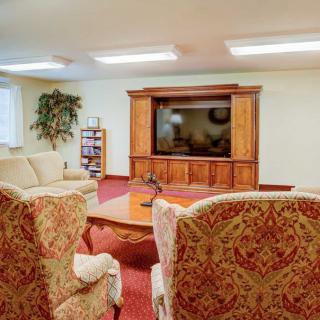 A cozy living room with comfortable seating and a large television in a wooden cabinet.