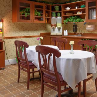A cozy kitchen and dining area with wooden furniture and decorative plants.