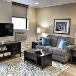 A cozy living room with a sofa, coffee table, and TV, featuring elegant decor and warm lighting.