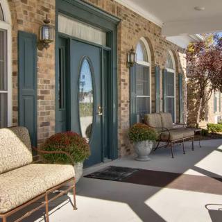 A welcoming front porch with seating and greenery.