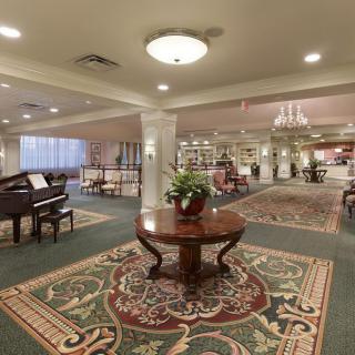 A spacious, elegantly decorated lobby featuring a grand piano and luxurious furnishings.