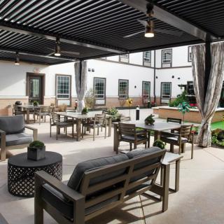 A stylish outdoor patio with comfortable seating under a pergola.