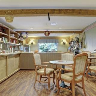 A cozy cafe interior featuring wooden furniture and an aquarium centerpiece.