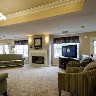 A cozy living room with a fireplace, comfortable seating, and a television.
