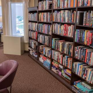 A cozy library interior with bookshelves filled with a variety of books.