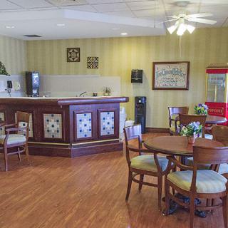 A cozy cafe interior featuring a wooden bar counter, seating area, and stylish decor.