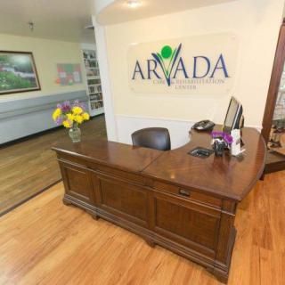 A reception area with a wooden desk and decorative flowers.