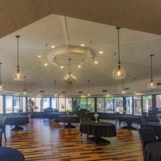 A spacious dining area with modern pendant lighting and wooden flooring.